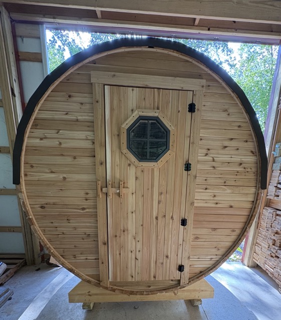 Fresh pine barrel sauna with octagonal window door, handcrafted inside an Amish workshop
